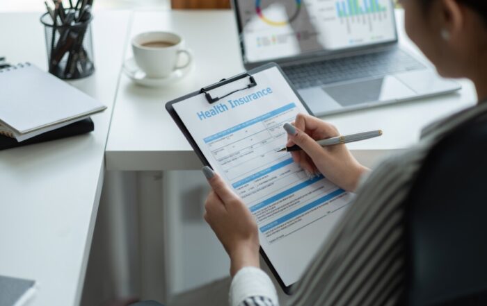 Asian woman review and sign on application for health insurance.