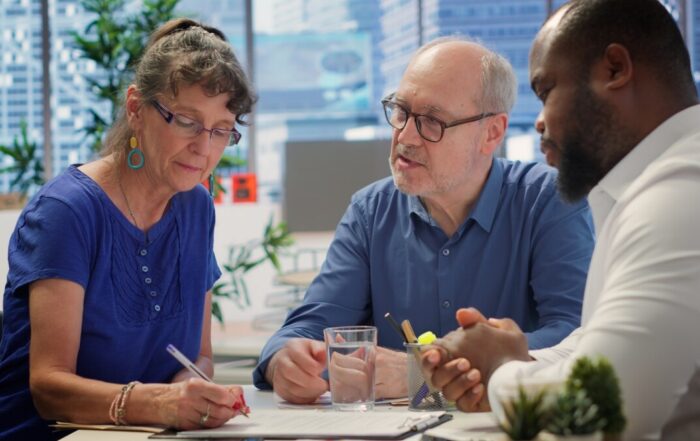 Middle aged couple explores life insurance contract terms with financial adviser