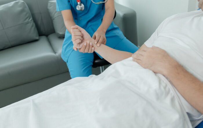 Patient on an inpatient hospital bed with a doctor examining and asking for information about the sy