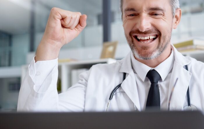 Laptop, man and doctor in celebration of success in hospital for healthcare goals, health achieveme