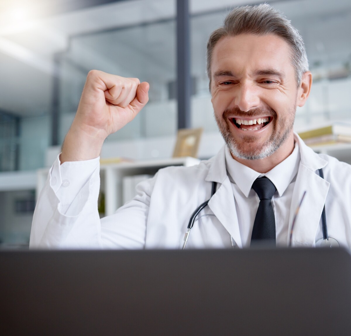 Laptop, man and doctor in celebration of success in hospital for healthcare goals, health achieveme